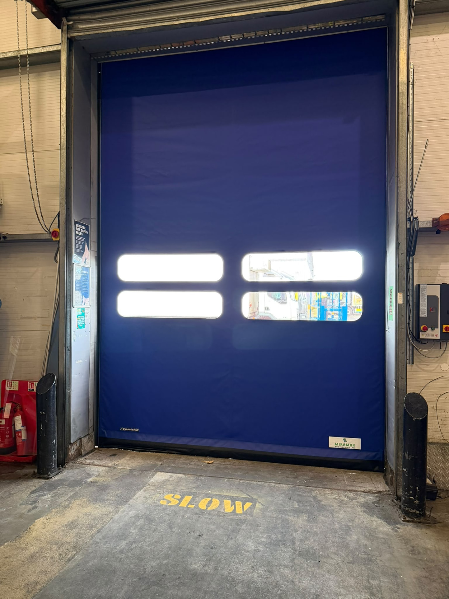 Blue high speed fabric door with vision panels inside a warehouse