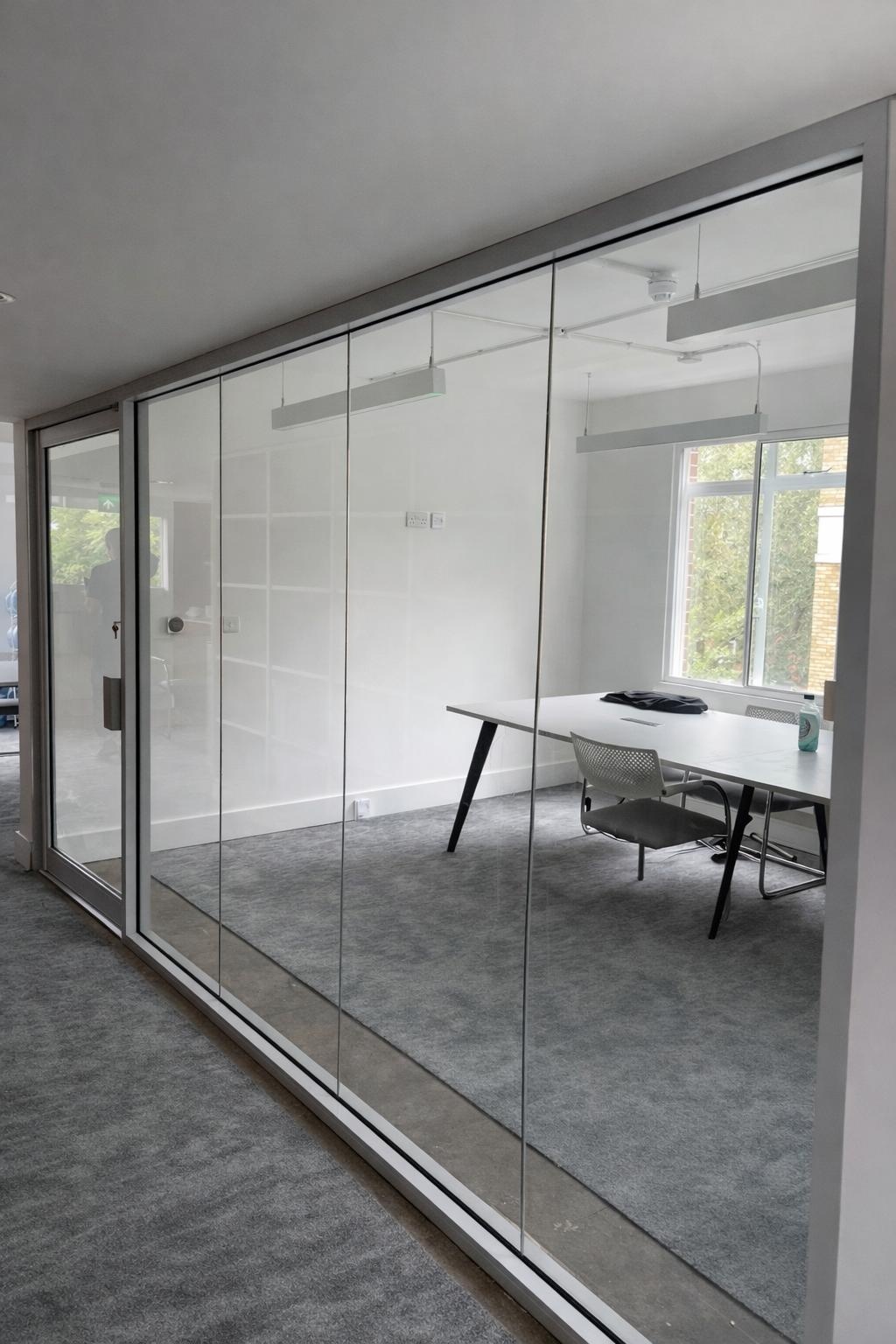 Frameless glass screen and door installed in an office interior