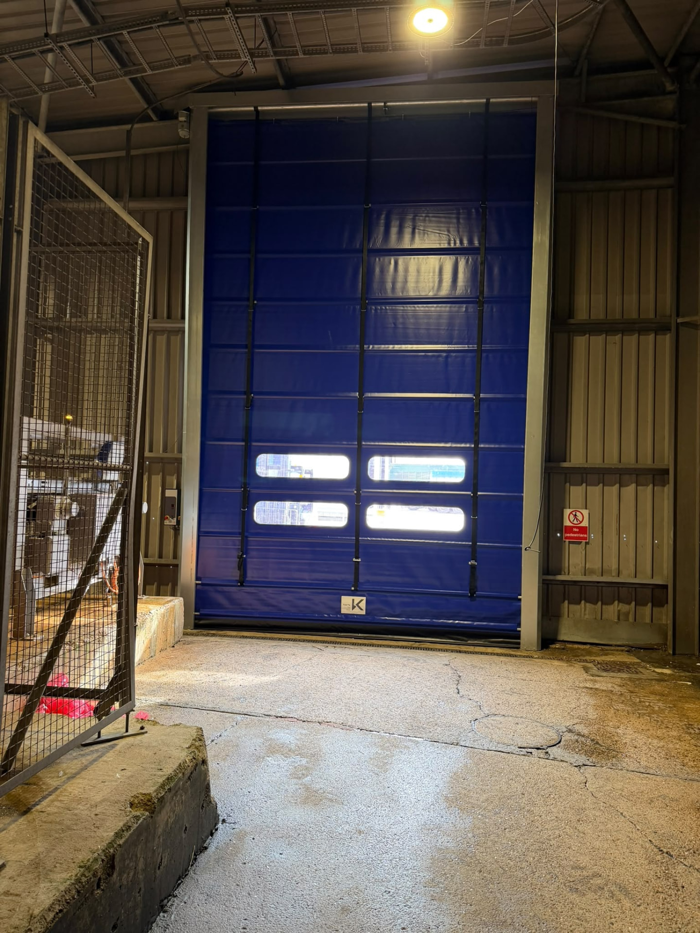 Industrial high speed door at a loading bay lit at night