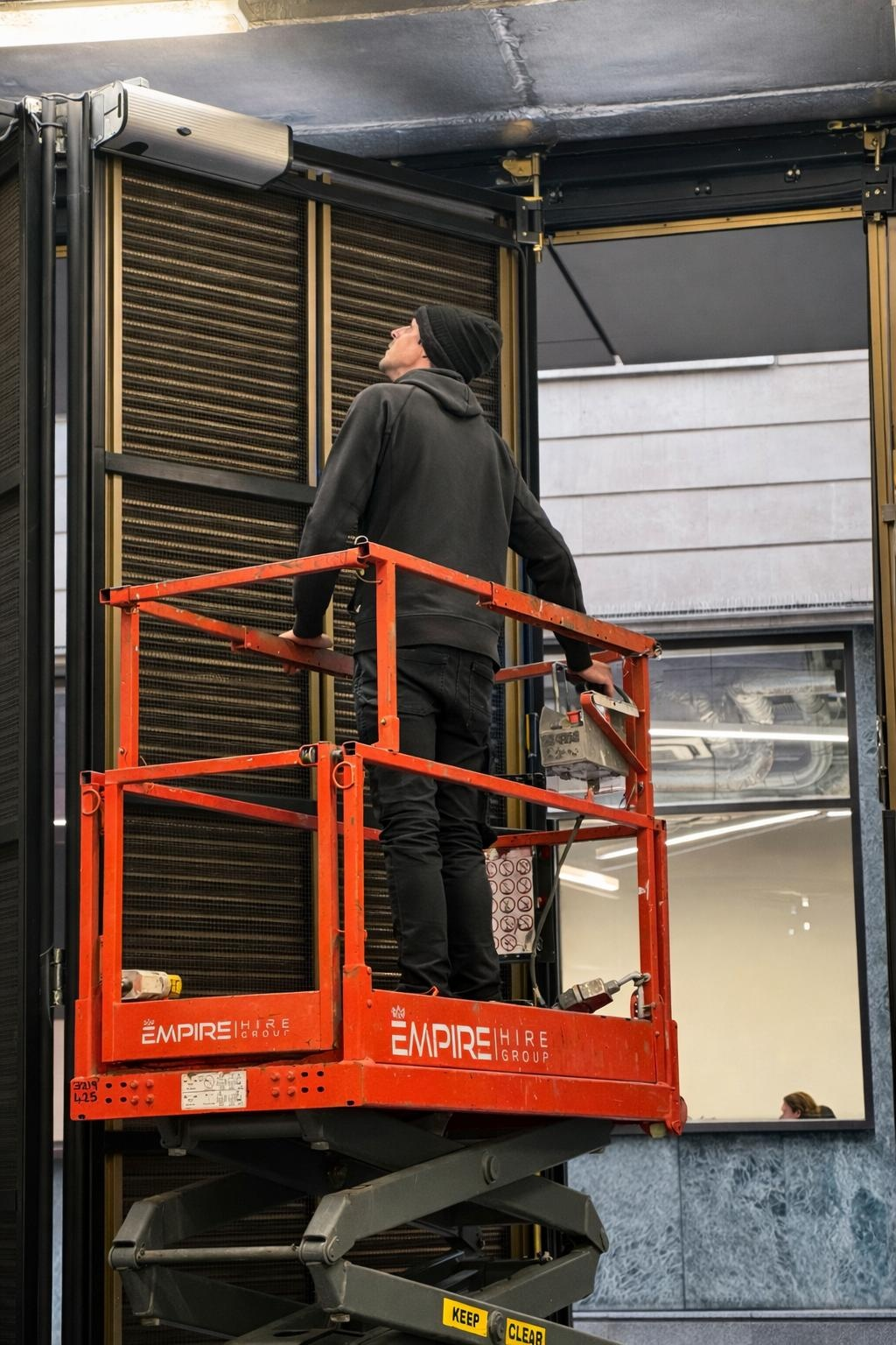 Argents Installations engineer on a scissor lift servicing an internal roller shutter above a commercial entrance