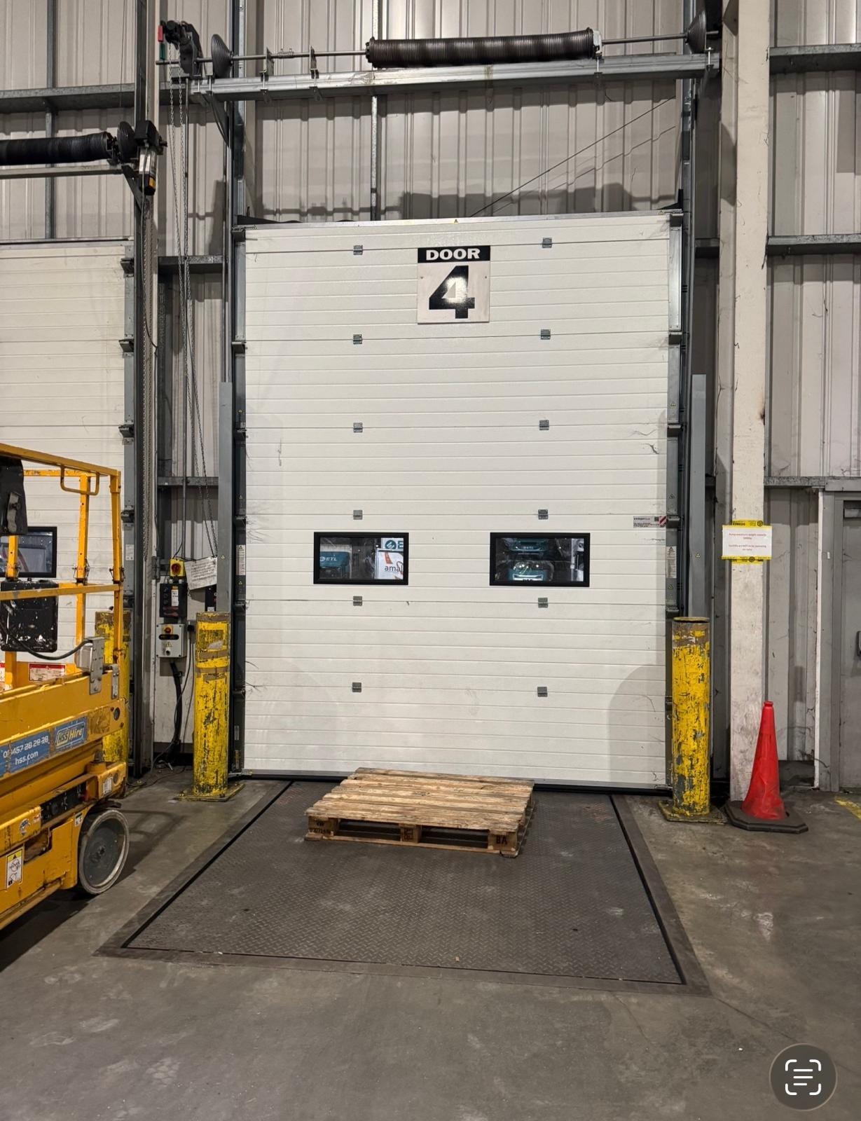 Dock leveller platform serving a warehouse loading bay door