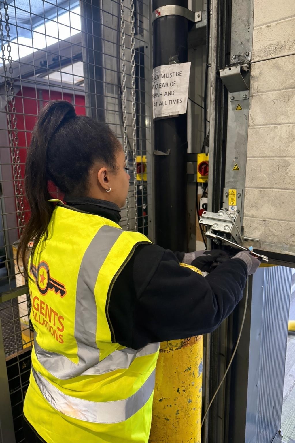 Argents Installations engineer servicing an industrial door mechanism on site