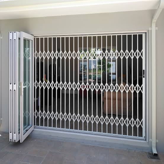 Concertina security grille fitted across a glazed commercial entrance